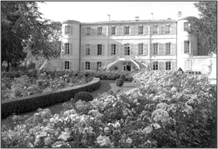 A large building with many windows and flowers in front of it Description automatically generated with low confidence